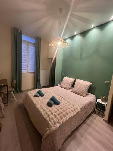 une chambre avec un lit avec deux pantoufles dessus dans l'établissement Le Bacchus - hypercentre de Reims, à Reims