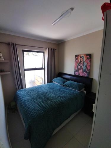 a bedroom with a bed and a window at 21 Pin Oak Guest House in Cape Town