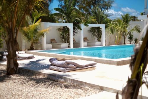 a pool with chaise lounges next to a resort at Antares Villa in Kiwengwa