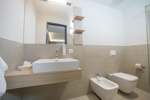 a bathroom with a sink and a toilet and a mirror at Summit of Saxony Resort Oberwiesenthal in Kurort Oberwiesenthal