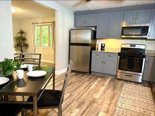 a kitchen with stainless steel appliances and a table at The House Hotels - Terrific W33rd in Cleveland