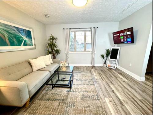a living room with a couch and a tv at The House Hotels - Terrific W33rd in Cleveland