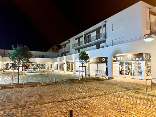 an empty street in front of a building at night at La Cabine d HARDELOT Plage à 3mn à pied in Neufchâtel-Hardelot