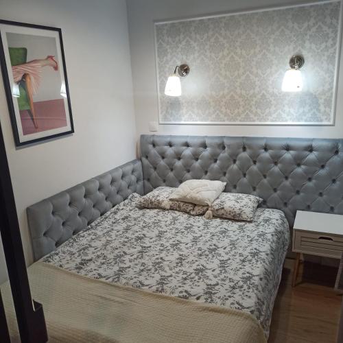 a bedroom with a large bed with a padded headboard at Apartament na Starówce in Elblag