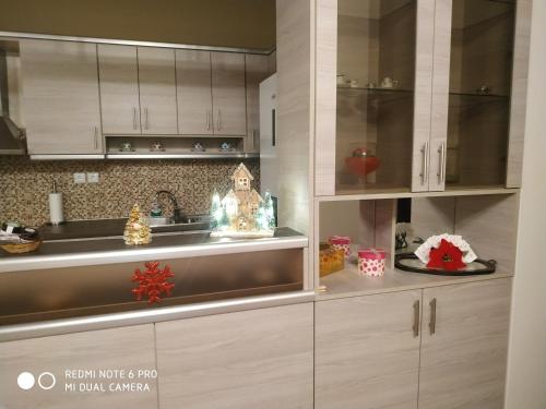a kitchen with white cabinets and christmas decorations at Villa Krina Rosa Aigio in Elíki