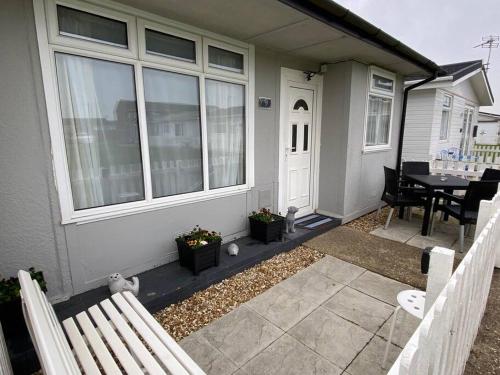 a porch of a house with a table and chairs at Sandy Paws in Trusthorpe
