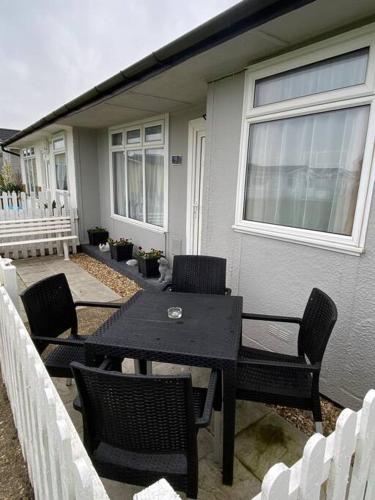 a black table and chairs in front of a house at Sandy Paws in Trusthorpe