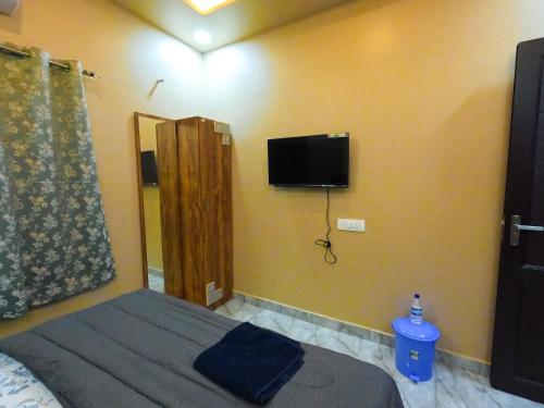 a bedroom with a bed and a tv on the wall at JFZ Homestay in Honāvar