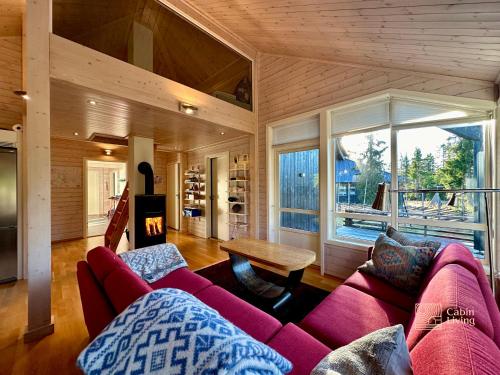 a living room with a red couch and a large window at Cabin at Sjusjøen Birkebeiner trail ski in out, 8 beds, 2 bathrooms & Wifi in Sjusjøen