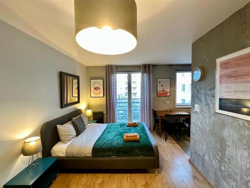 a bedroom with a bed and a living room with a table at MOMOApart - by Kromera in Wrocław