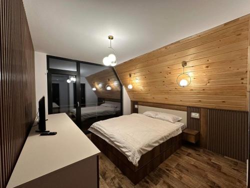 a bedroom with a bed and a desk with a computer at A 3 villa in Nucşoara