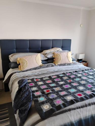 a bed with a blue headboard and pillows on it at Marina 1 piso 23 in Coquimbo
