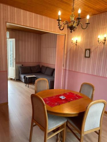 a dining room with a table and chairs and a couch at Maison calme proche Paris in Le Plessis-Robinson