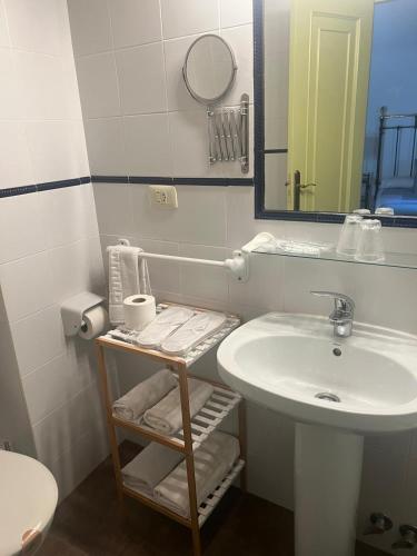a white bathroom with a sink and a mirror at Casa Blanco in Palas de Rei