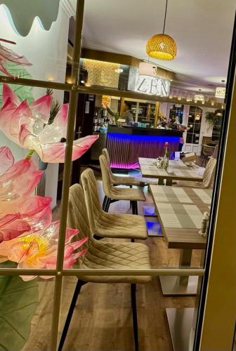 a view of a restaurant with a table and chairs at Hotel Wesselényi in Győr