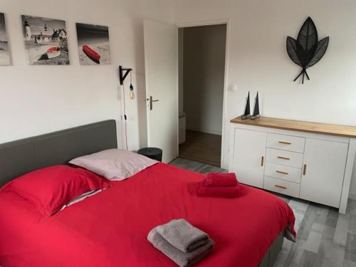 une chambre avec un lit rouge avec des serviettes dessus dans l'établissement Leclerc 217, à La Roche-sur-Yon