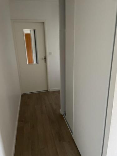 un couloir vide avec des murs blancs et du parquet dans l'établissement Leclerc 217, à La Roche-sur-Yon