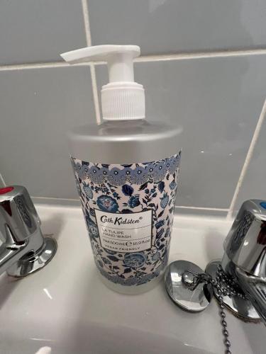 a bottle of soap sitting on top of a sink at The Friary House - Central Guildford Personal 1 Bedroom Budget Apartment in Guildford