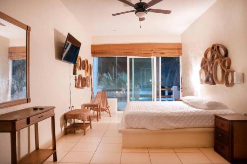 Un dormitorio con una cama y un escritorio y una ventana. en Casa Buena Vida Monterrico, en Taxisco