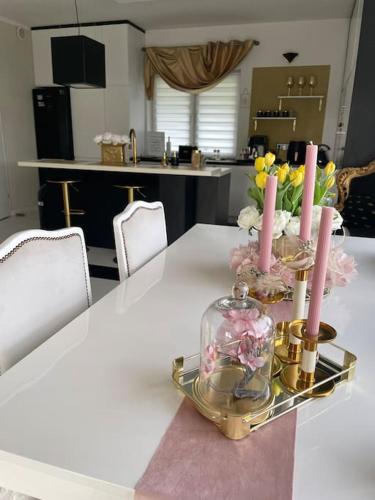 a table with two candles and a glass jar with flowers at Villa Stella Strandnah in Gryfice