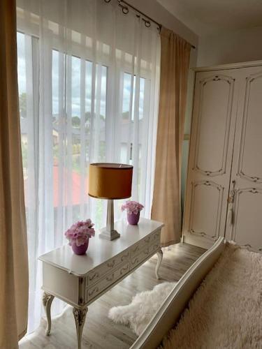 a lamp on a table in front of a window at Villa Stella Strandnah in Gryfice