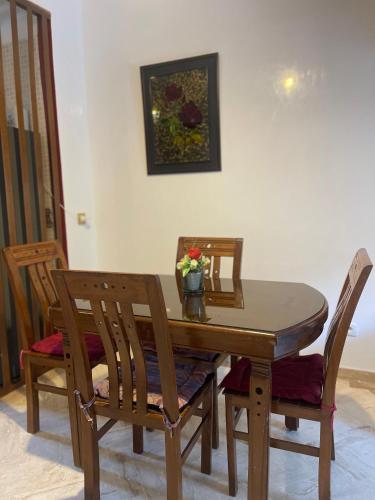 a dining room table and chairs with a vase of flowers on it at Atlas golf resort in Marrakech
