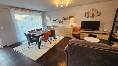 un salon avec une table, des chaises et une télévision dans l'établissement Le Repaire Malouin, à Saint-Malo