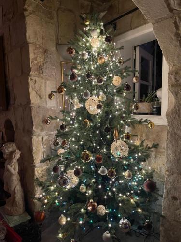 a christmas tree with ornaments on it in a fireplace at No 7 Casa Nannakola in Naxxar