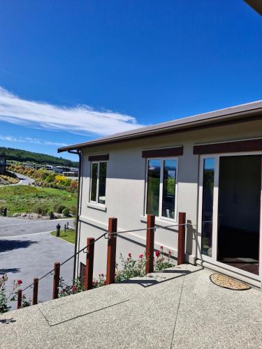 a building with a fence in front of it at Studio Nestled in Ridgecrest in Wanaka