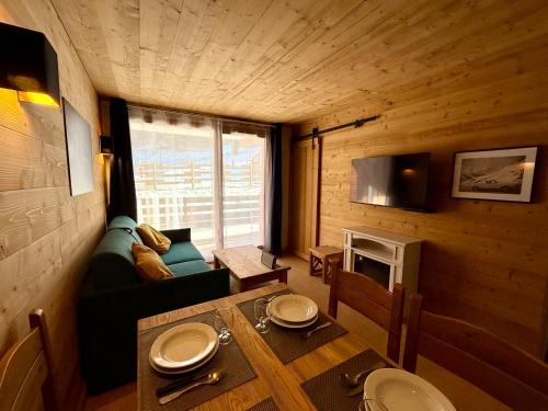 un petit salon avec une table et un canapé dans l'établissement Appartement aux Orres 1800 en RDC, aux Orres