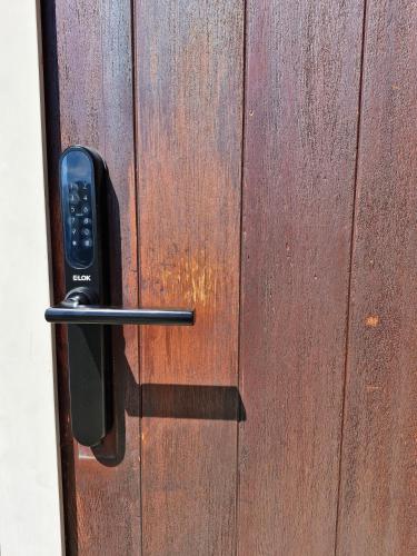 a wooden door with a remote control on it at Studio Nestled in Ridgecrest in Wanaka