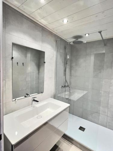 une salle de bain blanche avec un lavabo et une douche dans l'établissement Résidence Hameaux De Val - Votre grand studio mezzanine avec garage couvert à 5 min des pistes MAE-1004, à Val dʼIsère