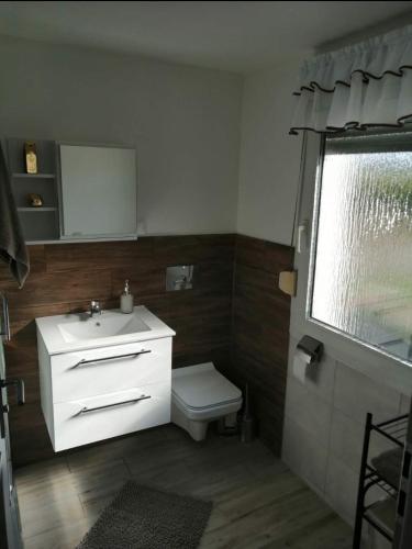 a bathroom with a white sink and a toilet at Domek POD LASEM in Opole