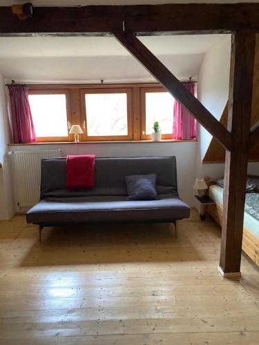a couch sitting in a room with windows at Pfarrhaus Tollensesee in Penzlin