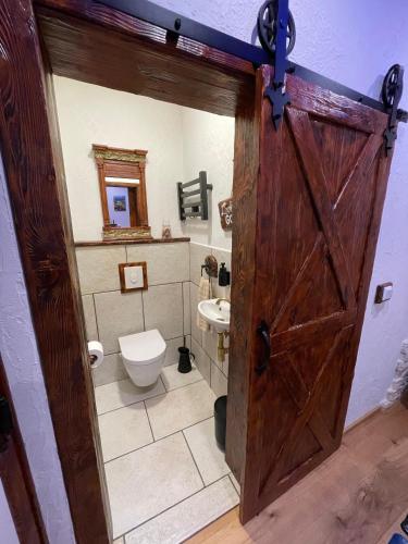 a bathroom with a wooden door and a toilet at Apartments Oliva in Fiorini