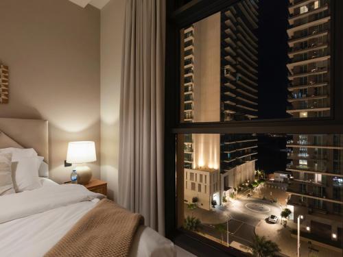 a bedroom with a bed and a view of a city at Cozy One Bedroom on the Beach in Dubai Harbour - Prestige Retreats in Dubai