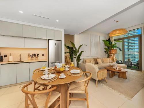 a kitchen and living room with a table and chairs at Cozy One Bedroom on the Beach in Dubai Harbour - Prestige Retreats in Dubai