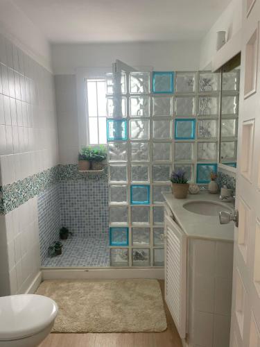 a bathroom with a sink and a shower with blue tile at La Perla del Mar in Estepona