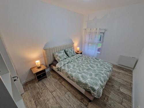 a small bedroom with a bed and two night stands at AU BON PLAN in Maubeuge