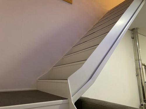 a staircase in a house with a white stair case at Dimora Casere 1 - zona centro - 200 mt da piste sci in Piancavallo