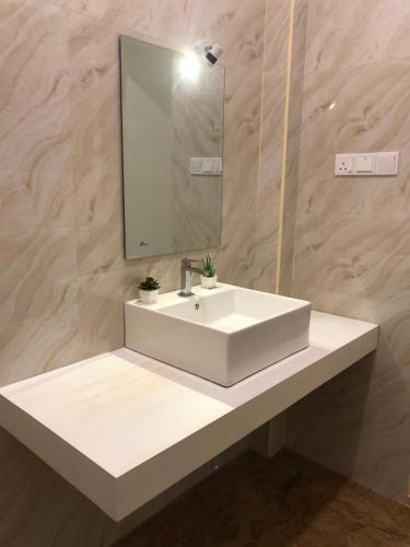 a bathroom with a white sink and a mirror at Traumvilla Mirissa in Mirissa