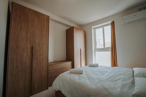 a bedroom with a bed and a large window at Brand new central located apartment in Iklin by SF Homes in Iklin