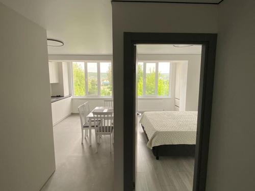 a bedroom with a bed and a table and chairs at Chirie apartament in Căuşeni