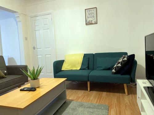 ein Wohnzimmer mit einer blauen Couch und einem Couchtisch in der Unterkunft Lovely Spacious House Family & Contractor Friendly 3 Bedroom Near Leeds Centre Sleeps 8 in Beeston