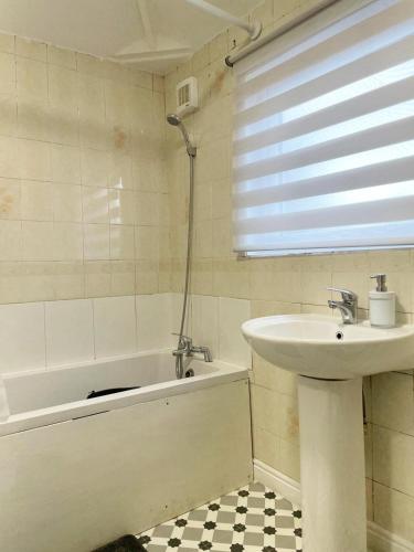 a bathroom with a sink and a bath tub and a sink at Lovely Spacious House Family & Contractor Friendly 3 Bedroom Near Leeds Centre Sleeps 8 in Beeston