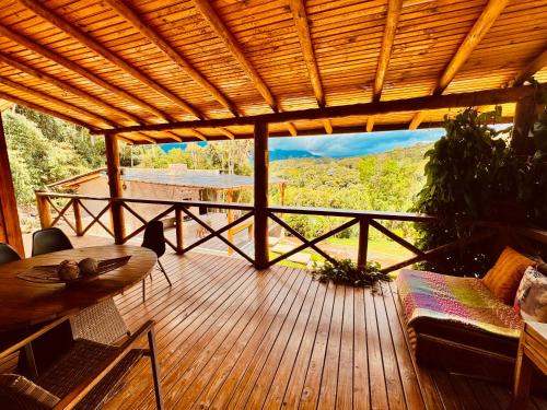 a wooden deck with a view of a mountain at Rancho do Lagarto Pedra Azul in Domingos Martins