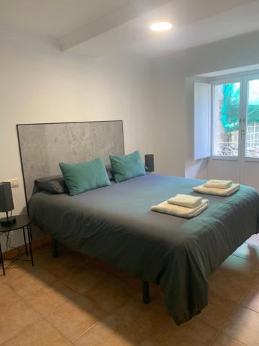 a bedroom with a large bed with towels on it at A Casa do Sastre1 in Ribadavia