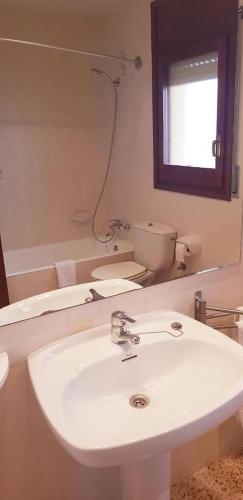 a white bathroom with a sink and a mirror at Hostal Braseria Missamaroi in Tivissa