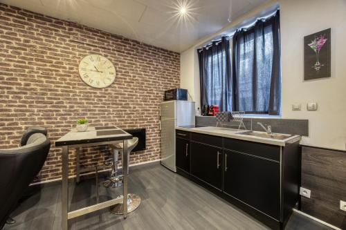 - une cuisine avec un évier et un mur en briques dans l'établissement street Loft with sauna, à Saint-Étienne