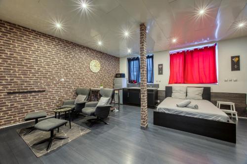 1 dormitorio con cama, sillas y pared de ladrillo en street Loft with sauna, en Saint-Étienne